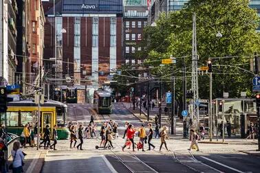 Raitiovaunuja Simonkadun ja Mannerheimintien risteyksessä. Ihmisiä ylittää Simonkadun.