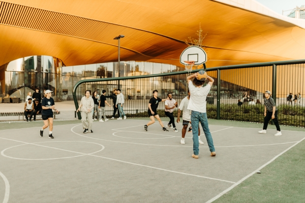 Nuoria pelaamassa koripalloa Oodi-kirjaston edessä.
